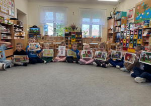 Dzieci trzymają w ręku ilustracje do opowiadania.