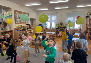Dzieci odbijają balony do góry.