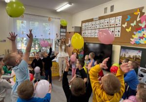 Dzieci tańczą z balonami przy muzyce.