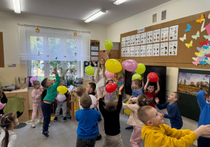Dzieci bawią się z kolorowymi balonami.
