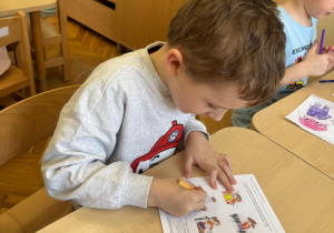 Chłopiec podczas kolorowania pracy.