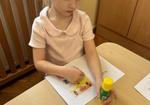 Dziewczynka wkleja do dzienniczka postać Tremka.