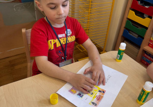 Chłopiec wkleja postać Tremka do swojego dzienniczka Czuciaków.