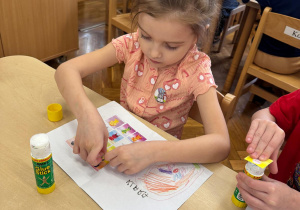 Dziewczynka wkleja do swojego dzienniczka Tremka z Wyspy Wstydu.