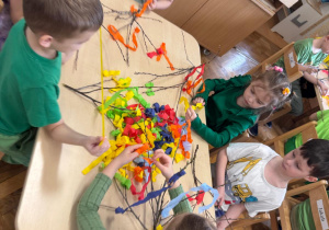 Dzieci zaczynają dekorować gałązki.