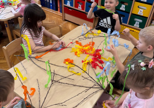 Dekorowanie gałązek bibułą i kwiatami - kreatywna praca dzieci.