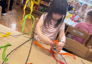 Dziewczynka z zaangażowaniem dekoruje swój gaik.