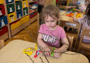Dziewczynka w skupieniu ozdabia swój gaik.