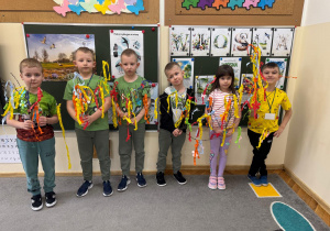 Dzieci z dumą prezentują swoje wiosenne ozdoby.