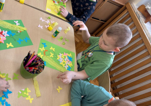 Chłopcy twworzą kolorową pracę.