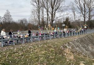 Kolorowy pochód ustawiony na moście żegna Marzannę.