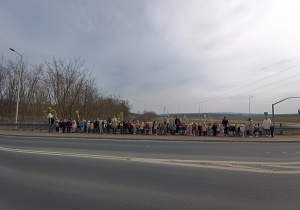 Przedszkolaki z kolorowymi gaikami i marzanną pozują do zdjęcia.