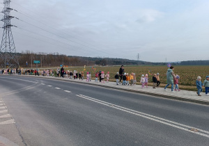Dzieci w kolorowym pochodzie wracają do przedszkola.