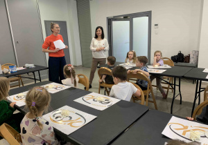 Przedszkolaki słuchają pań instruktorek z Domu Kultury.