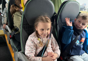 Zadowolone dzieci wracają autobusem do przedszkola.