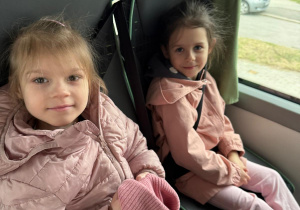 Uśmiechnięte dziewczynki wracają autobusem.