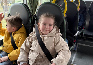 Uśmiechnięta dziewczynka w autobusie.