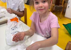 Dziewczynka sadzi nasionka.