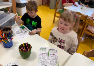 Dzieci kolorują domki.