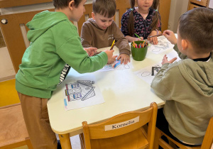 Dzieci kolorują domki.