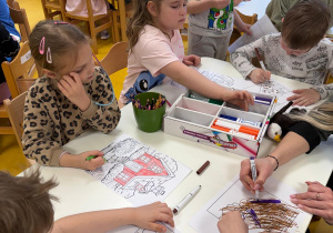 Dzieci kolorują domki.