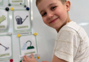 Chłopiec wiesza podpis do zdjęcia.