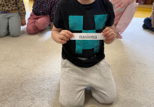 Chłopiec trzyma napis.