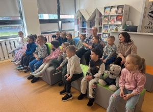 Dzieci siedzą i słuchają bajki.