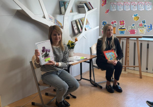 Pani pokazuje zagadkę z wiosennym kwiatem.