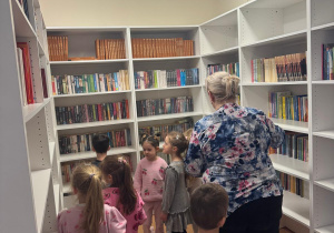 Dzieci oglądają zbiory biblioteczne.