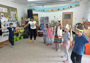 Sześciolatki trzymają się za ręce pani animatorki.