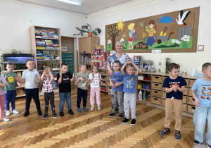 Pięciolatki stojąc klaszczą w dłonie.