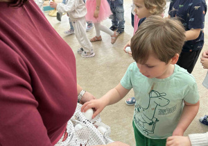 Dzieci wkładają jajka do fartuszka.