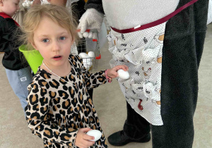 Dzieci wkładają jajka do fartuszka.