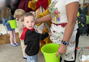 Dzieci wkładają jajka do fartuszka.