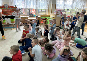 Dzieci siedzą w kole.