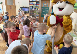 Dzieci przybijają piątki z zajączkiem.