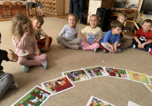 Dzieci oglądają ilustracje do opowiadania o Tremku.