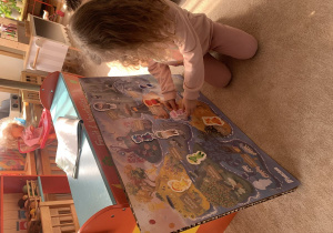 Dziewczynka umieszcza kolejnego Czuciaka na planszy.