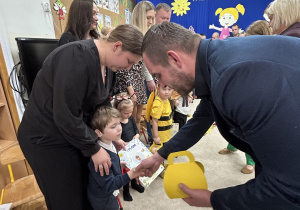 Wójt wręcza kuferek chłopcu.