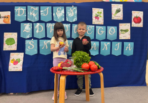 Dzieci trzymają w ręku jabłka.