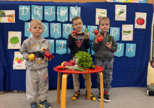 Chłopcy trzymają w ręku swoje ulubione owoce i warzywa.