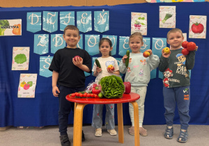 Dzieci pozują do zdjęcia z jabłkami i wybranymi przez siebie warzywami.