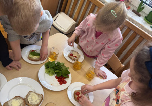 Dzieci przygotowują samodzielnie kanapki.