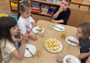 Dzieci podczas jedzenia jabłka.