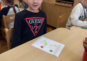 Chłopiec pozuje ze swoją pracą.