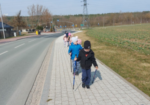 Przedszkolaki maszerują z kijkami.
