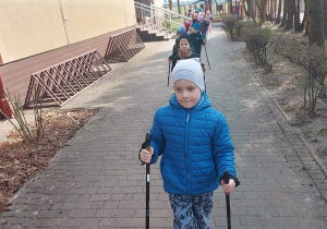 Przedszkolaki maszerują z kijkami.