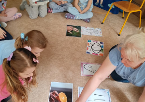 Dzieci patrzą na wskazywaną przez nauczyciela ilustrację.