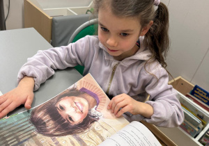 Dziewczynka ogląda czasopismo.